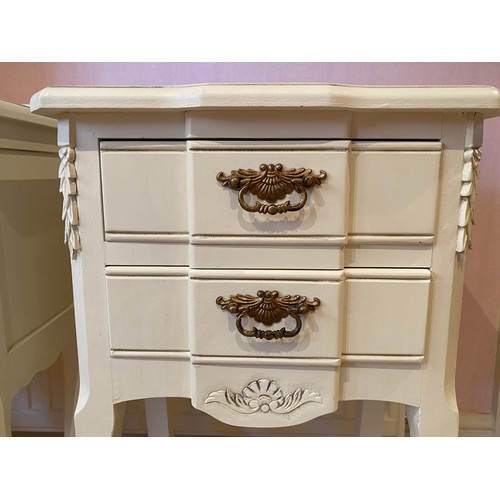 133 - A pair of cream painted two drawer bedside units with brass drop handles. 66cm h x 40cm w x 28.5cm d... 