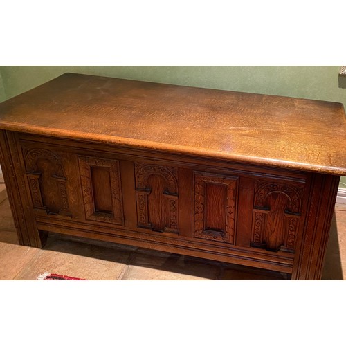 135 - A carved oak coffer with carvings to front and sides. 113 w x 51 h x 46cm d.