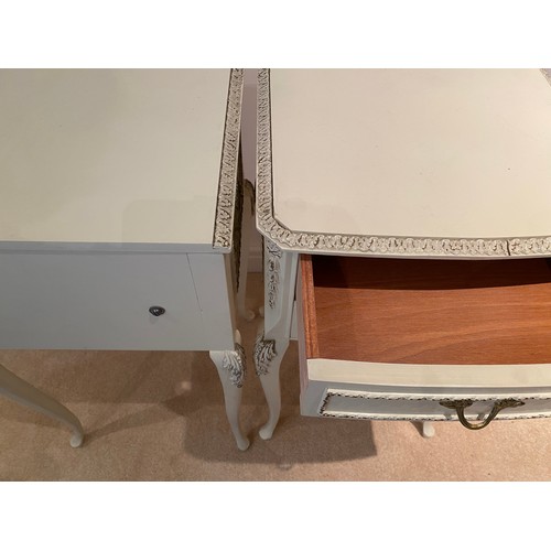 140 - A pair of cream and gilt bedside tables with two drawers to front raised on cabriole legs. 68cm h x ... 