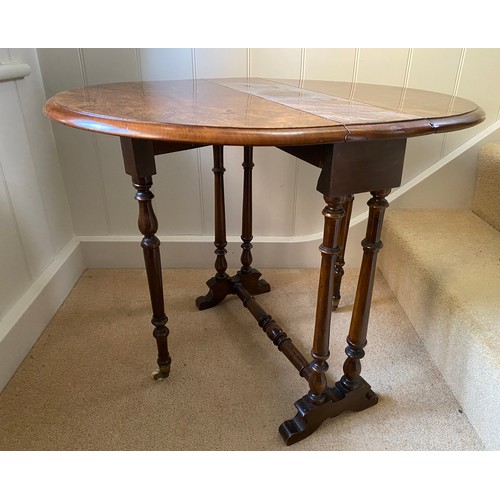 142 - A 19thC burr walnut oval drop leaf table on white porcelain castors. Open 70 x 53 x 53cm h. Closed 1... 