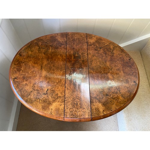 142 - A 19thC burr walnut oval drop leaf table on white porcelain castors. Open 70 x 53 x 53cm h. Closed 1... 