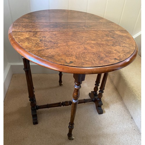 142 - A 19thC burr walnut oval drop leaf table on white porcelain castors. Open 70 x 53 x 53cm h. Closed 1... 