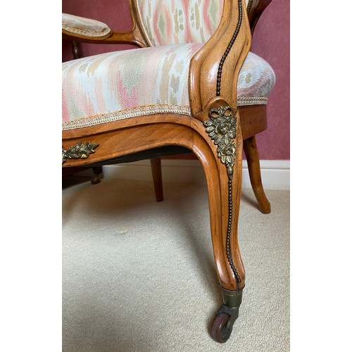 148 - A 19thC upholstered open armchair with gilt mounts and cabriole legs.