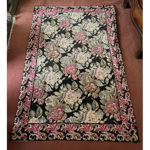 1221 - A 20thC tapestry rug, black background with pink and pastel roses. 176 x 226cm.