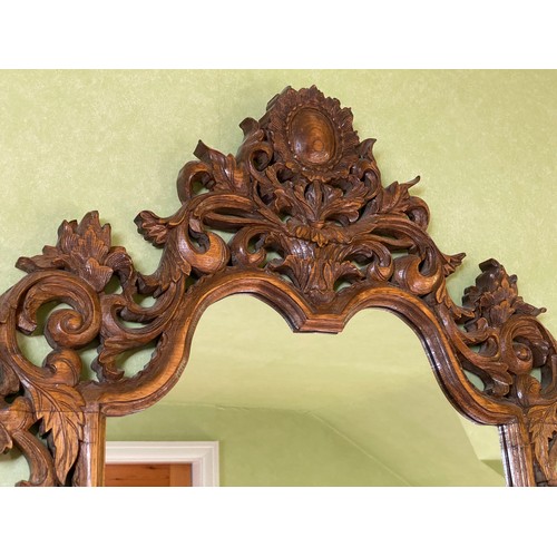 1142 - A decorative carved oak wall mirror.