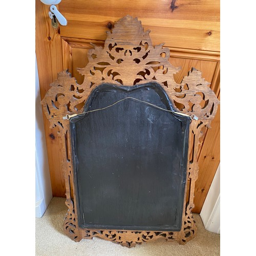 1142 - A decorative carved oak wall mirror.