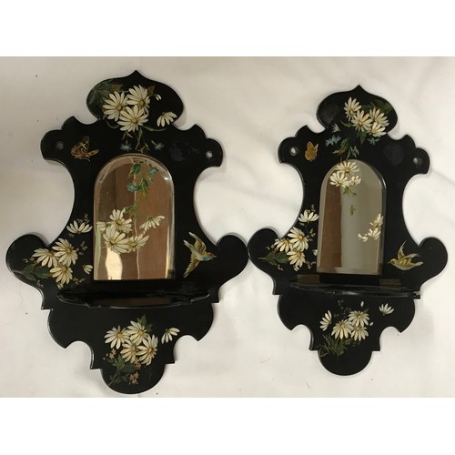 1143 - A pair of 19thC papier mache framed black wall mirrors with shaped outlines and folding shelves, arc... 