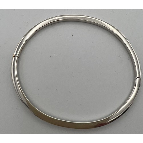 612 - An 18-carat white gold hinged bangle. Weight 8.5gm. Diameter 19.5cm.