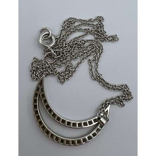 620 - An 18 carat white gold crescent moon pendant, 2.2cm top to bottom set with diamonds on a fine chain ... 