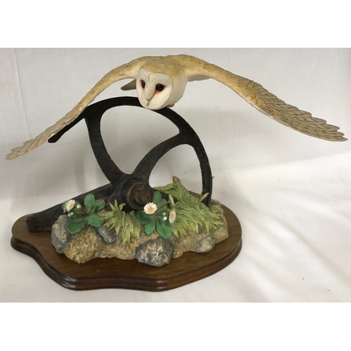 1014 - Pair of Border Fine Arts Owls one flying and one perched on a piece of wood. Largest 26 x 40cm.