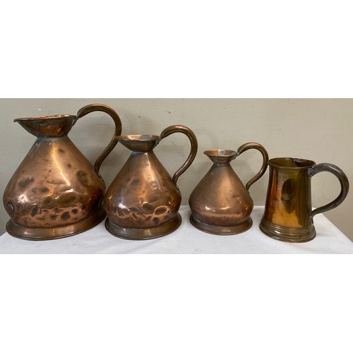 1059 - Three graduated copper measures together with a copper tankard. Largest jug 28cm h.