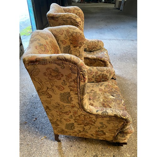 20 - Two upholstered wing back chairs on cabriole legs and castors in need of restoration. Tallest to the... 