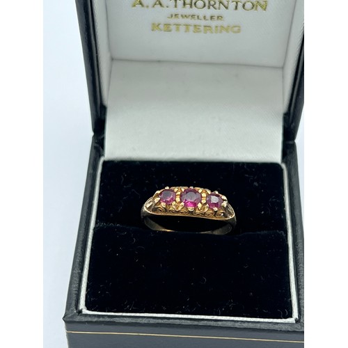 601 - A nine carat gold ring set with three garnets. Size N. Weight 1.9gm.