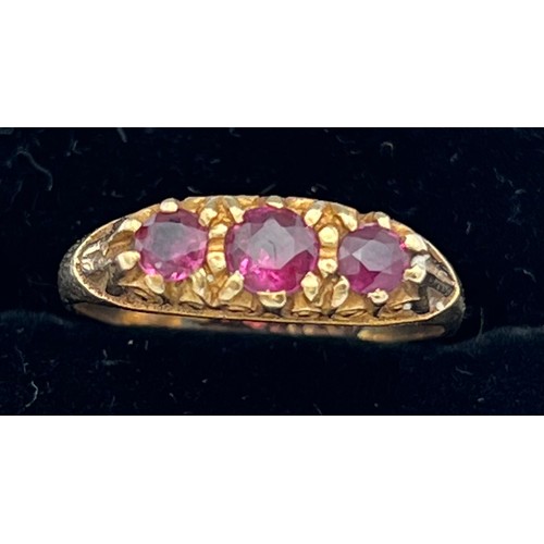 601 - A nine carat gold ring set with three garnets. Size N. Weight 1.9gm.