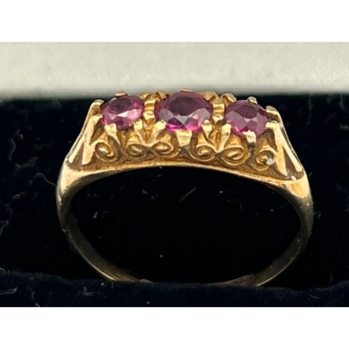 601 - A nine carat gold ring set with three garnets. Size N. Weight 1.9gm.