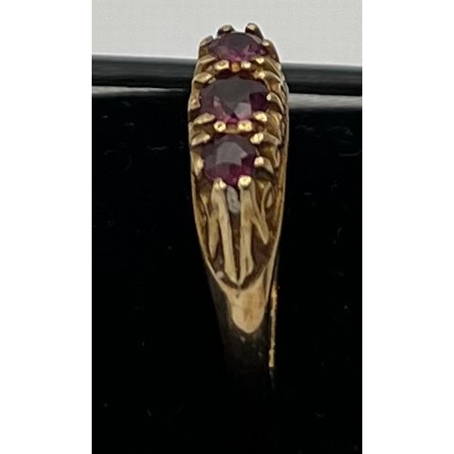 601 - A nine carat gold ring set with three garnets. Size N. Weight 1.9gm.