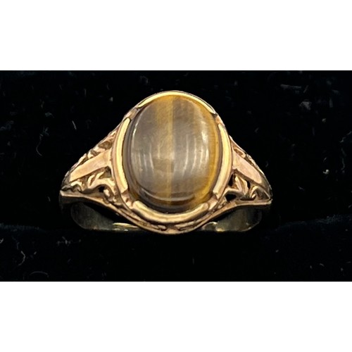 604 - A nine carat gold ring set with tigers eye. Size I. Weight 2.4gm.