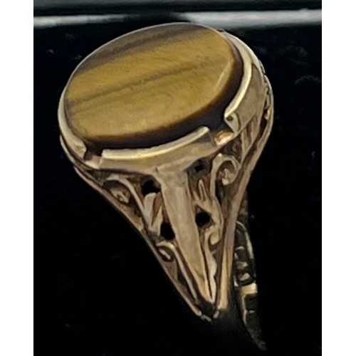 604 - A nine carat gold ring set with tigers eye. Size I. Weight 2.4gm.