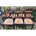 A set of 7 early 20thC oak and rush seated dining chairs.