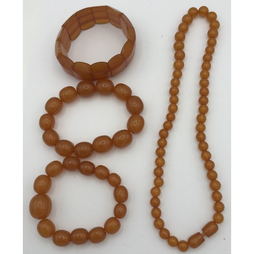 513 - Four amber coloured pieces of jewellery to include a bead necklace 45cm l, two bead bracelets and a ... 