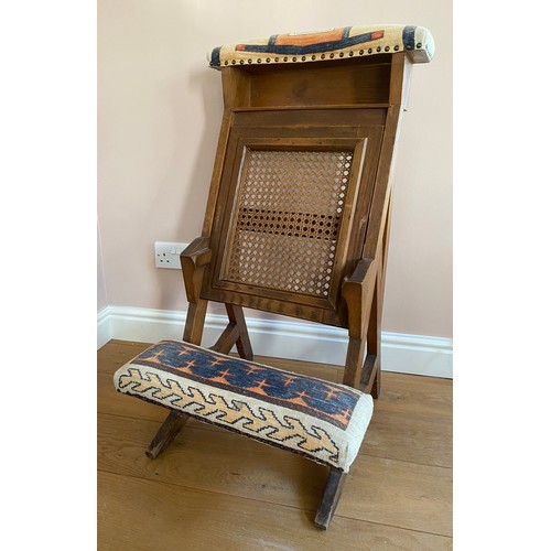 41 - A 19thC oak chair with upholstered footrest and top with cane seat.