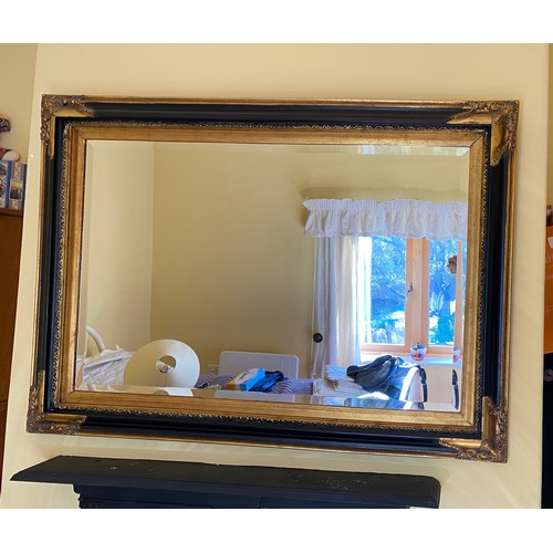 1150 - A modern black and gilt bevelled edge wall mirror 80 h x 110cm w.