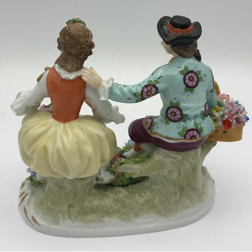 378 - A Sitzendorf figure of a couple sitting together with flowers