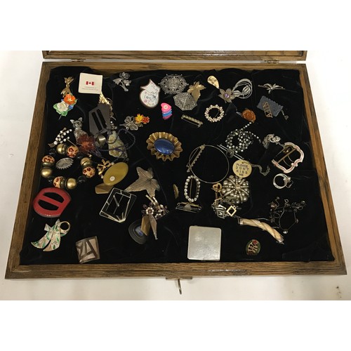 463 - A glass display cabinet displaying an assortment of costume jewellery to include brooches, earrings ... 