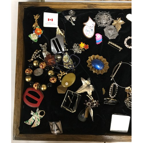 463 - A glass display cabinet displaying an assortment of costume jewellery to include brooches, earrings ... 