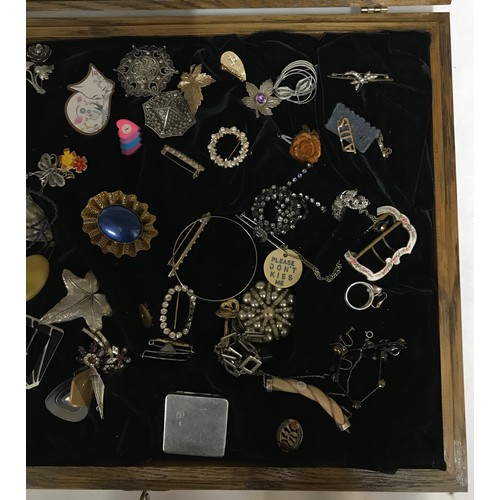 463 - A glass display cabinet displaying an assortment of costume jewellery to include brooches, earrings ... 