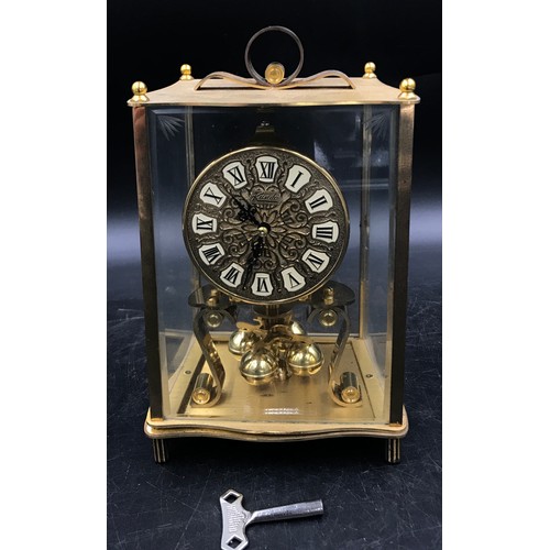 1198 - A brass Kundo mantel clock, 23cm h in glass case.