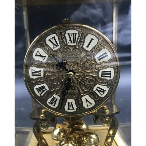 1198 - A brass Kundo mantel clock, 23cm h in glass case.