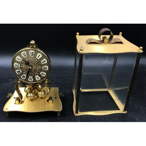 1198 - A brass Kundo mantel clock, 23cm h in glass case.