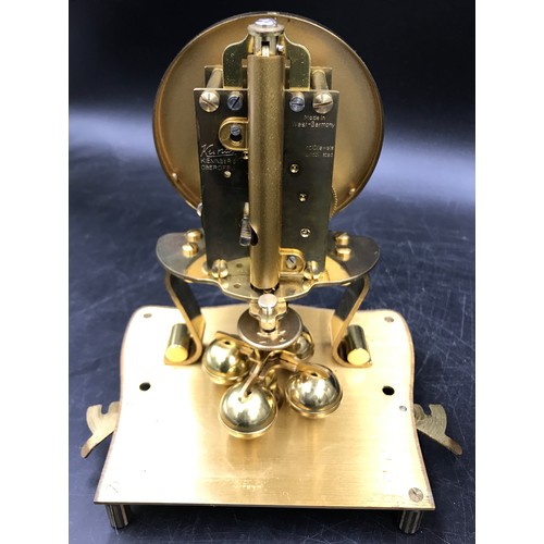 1198 - A brass Kundo mantel clock, 23cm h in glass case.