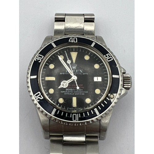 A Rolex Sea-Dweller Submariner 2000 - Double Red - Reference: 1665 from 1978. The dial features the 'double red' printed Sea-Dweller on the first line, and Submariner 2000 on the second with a black dial. The 'Sea-Dweller 2000' was one of the first production watches to employ a gas-escape valve on the band of the case, which allows the interior of a watch to decompress and avoids damage. Case no. 5298193. Mod 1665, B/Let 93150, Cal 1570, M/M D108030. Last service at Rolex 2014.
