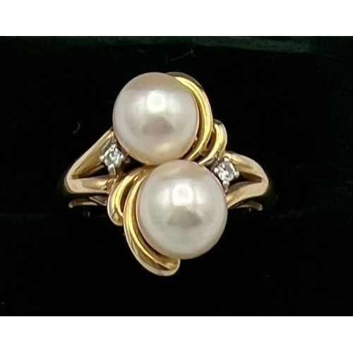 506 - A 14 carat yellow gold ring set with two cultured pearls and two diamonds. Weight 4gm. Size L.