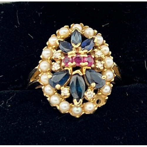 508 - A 14 carat gold ring set with seed pearls, sapphires, diamonds and rubies. Size O. Weight 5.6gm.