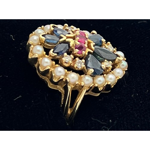 508 - A 14 carat gold ring set with seed pearls, sapphires, diamonds and rubies. Size O. Weight 5.6gm.