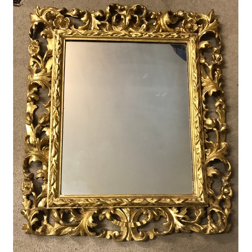 1145A - A 19thC ornate gilt wood framed mirror with replacement back. Frame 107 x 90cm.