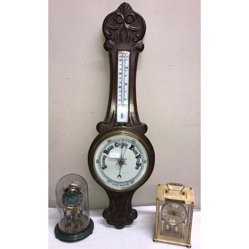 1182 - An oak aneroid barometer with thermometer. 84 h x 26cm w together with a gilt and green Kundo annive... 