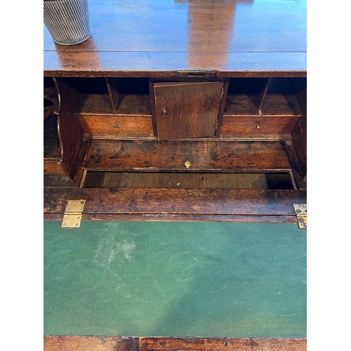 180A - A 18thC oak bureau on bracket feet with fitted interior and lidded compartment. 104 h x 59 d x 97cm ... 