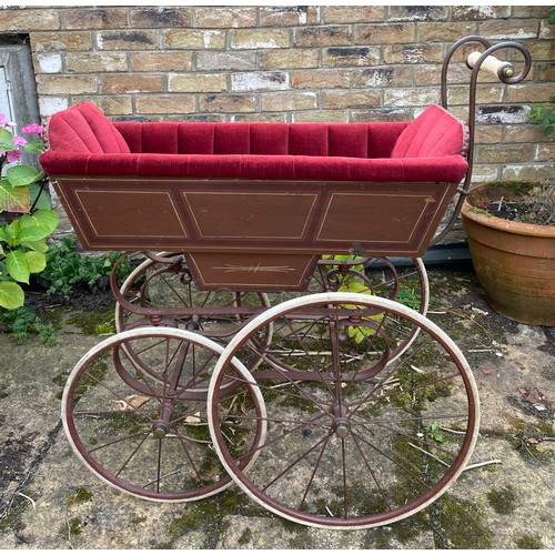 1103 - A 19thC wood and iron pram with ceramic handle with recently upholstered interior. 93 l x 48cm w.