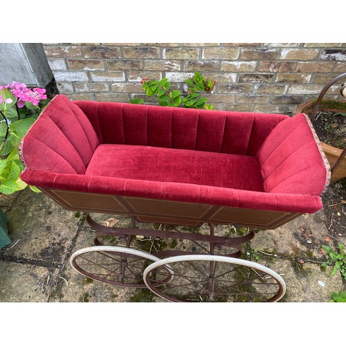 1103 - A 19thC wood and iron pram with ceramic handle with recently upholstered interior. 93 l x 48cm w.