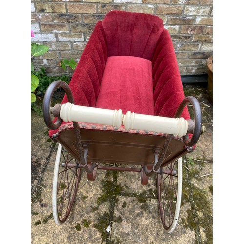 1103 - A 19thC wood and iron pram with ceramic handle with recently upholstered interior. 93 l x 48cm w.