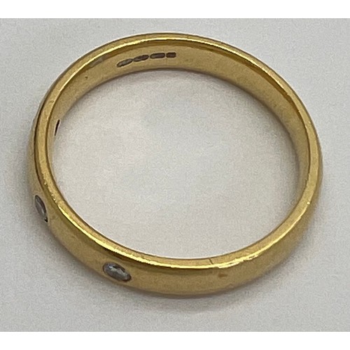 411 - An 18 carat diamond set gold wedding band. Weight 4.9gm. Size P. Marked 750.