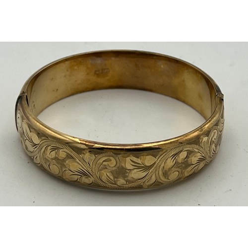 426 - A 9 carat yellow gold bangle, engraved to one side. Weight 18gm.