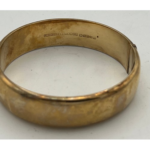 426 - A 9 carat yellow gold bangle, engraved to one side. Weight 18gm.