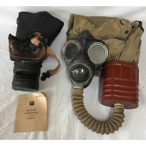 1094 - Two vintage gas masks both with fitted bags one with a Military operations in the desert booklet.