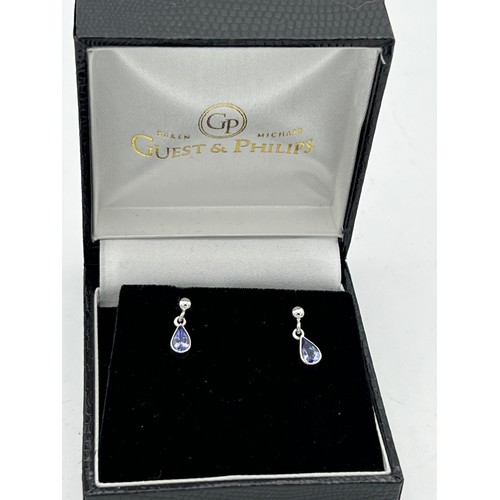 435 - Eighteen carat white gold earrings set with purple stones.