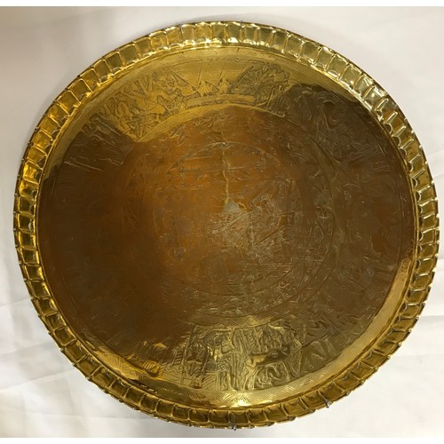 817 - A large brass table top with Egyptian style decoration measuring 61cm in diameter along with a brass... 